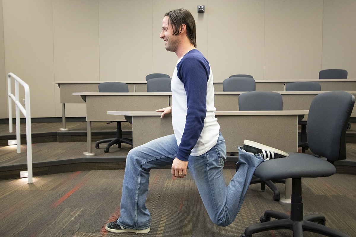 Adult doing lunges with a chair