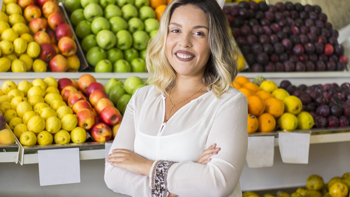Adult in front of grocery fruit shelves