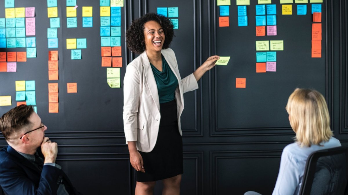 Adult in meeting at board with notes