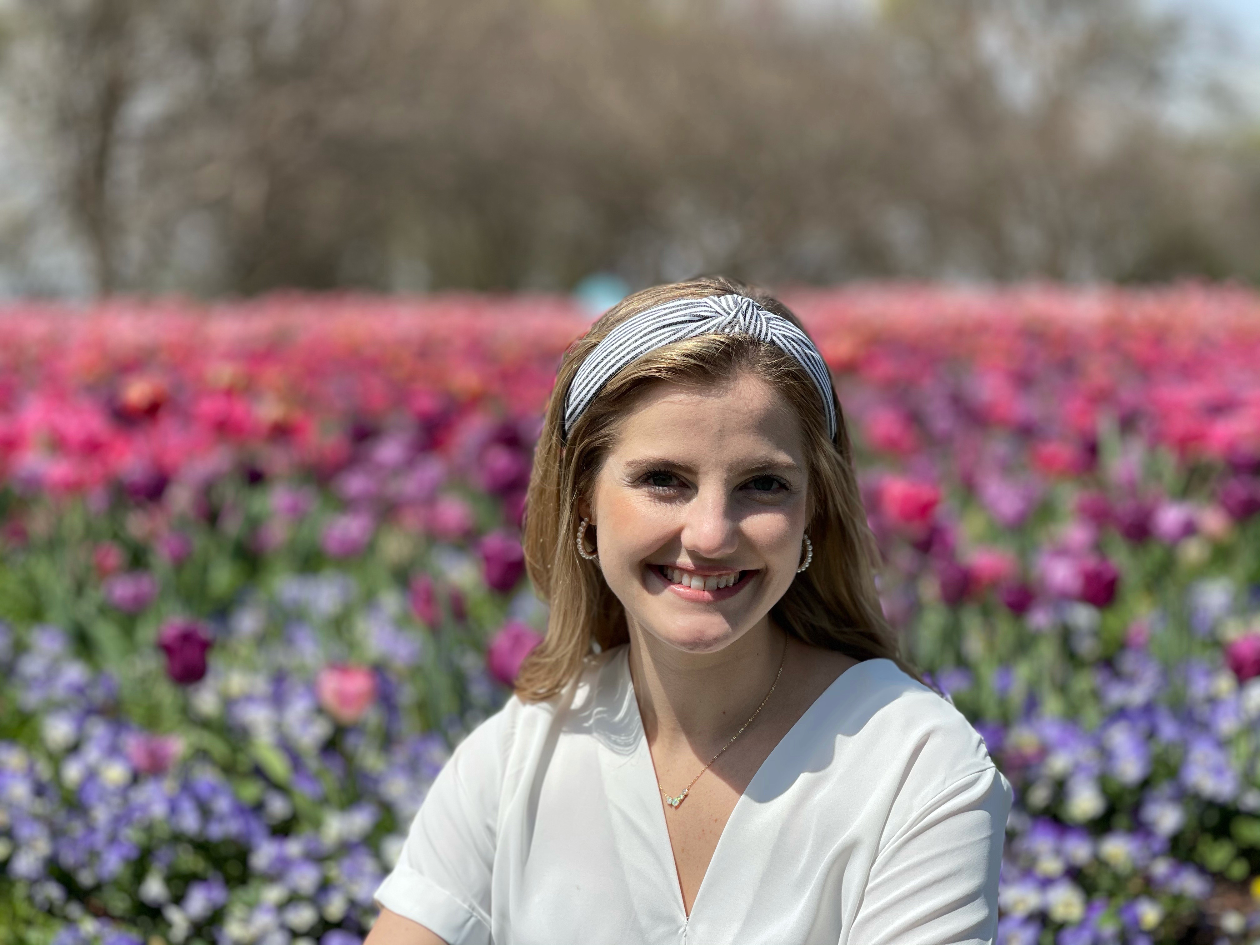 Jessika Tucker smiles amongst flowers outdoors