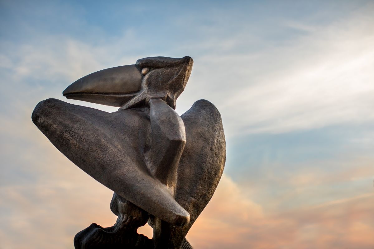 The bronze Jayhawk outside of Regnier Hall at sunrise