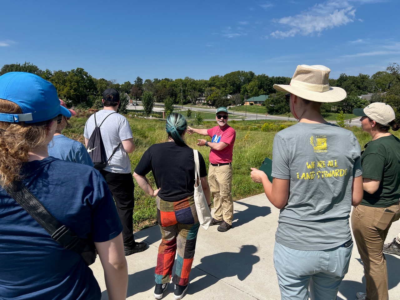 KU Environmental Assessment students listen as an instructor describes a stormwater green infrastructure site during a Kansas City field visit.
