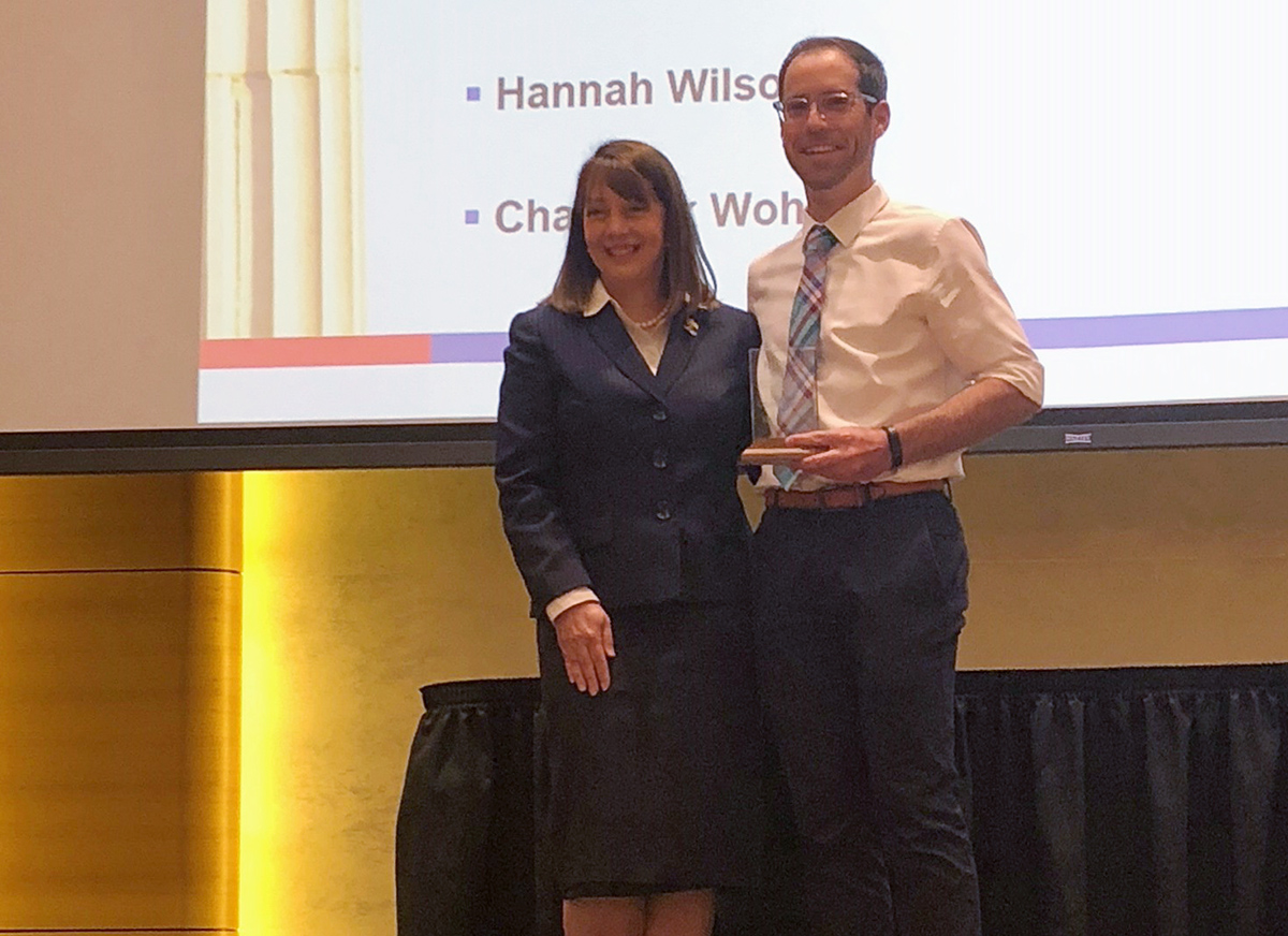 L. Paige Fields, dean and Henry D. Price Professor of Business at the KU School of Business joins Chadwick Wohletz onstage as he receives the RESPECT Positive Code of Conduct Award in April 2018. (Photo credit: Heather Norris)