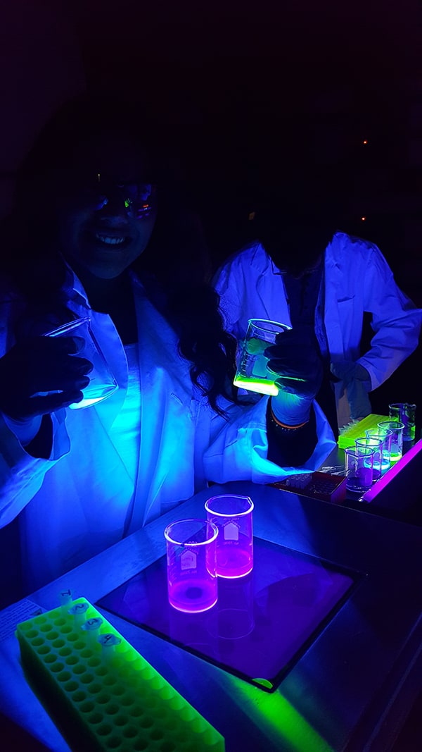 Glow in the dark students doing an experiment