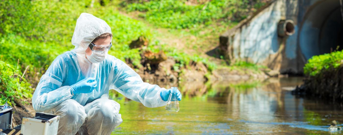 Woman sampling water in a stream